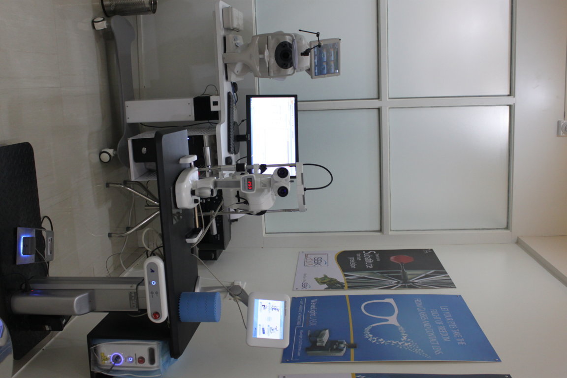 Refractive surgery workup table at Insight Institute angled toward the WaveLight LASIK and Oculyser II patient education panels on the wall